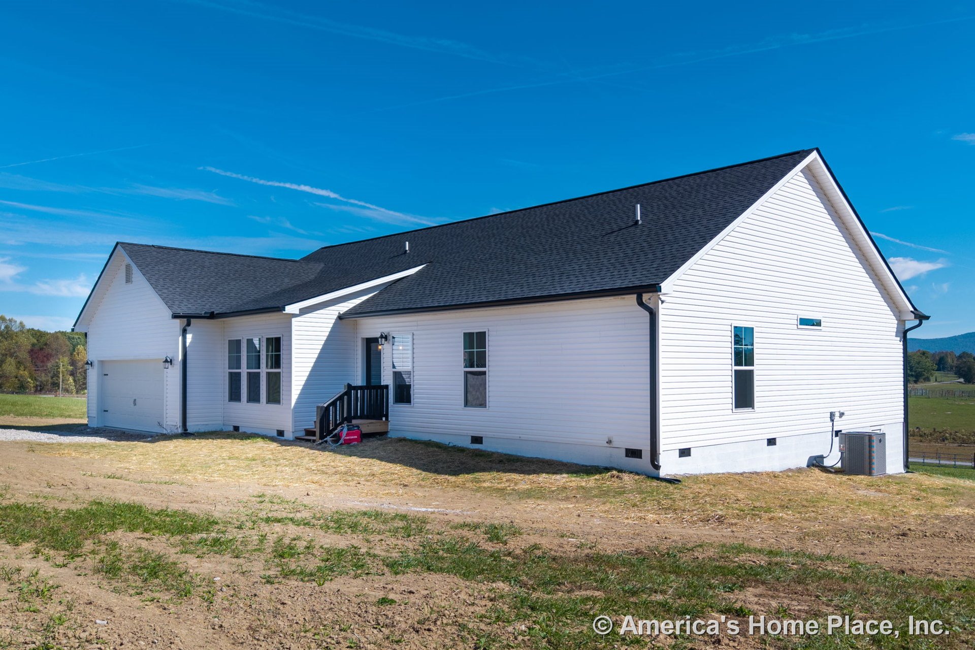 White vinyl siding exterior with black asphalt shingle roof, attached two-car garage, covered front porch with steps, double-hung windows, exterior lighting fixtures, entry door