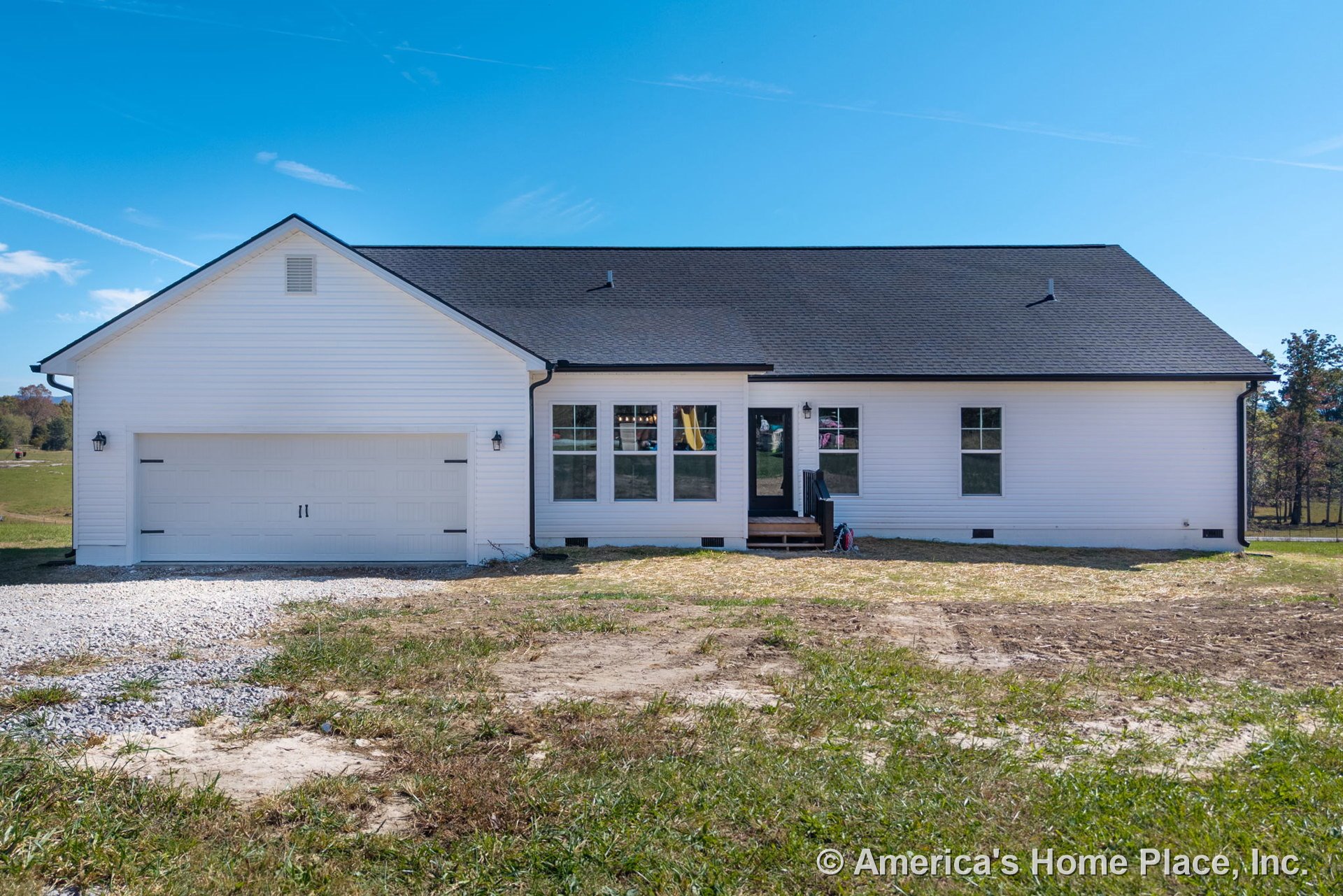 White vinyl siding exterior with black shingle roof, attached two-car garage featuring carriage-style doors, multiple grid windows, covered entry porch with steps, exterior