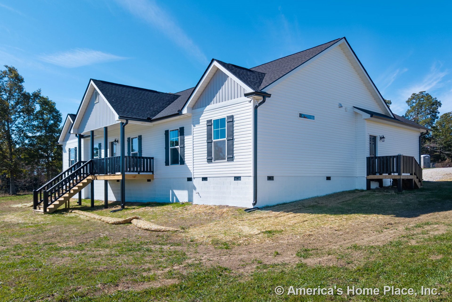 White horizontal siding and black shingle roof with black window shutters, two covered porches featuring black railings, raised entry stairs, and concrete block foundation.