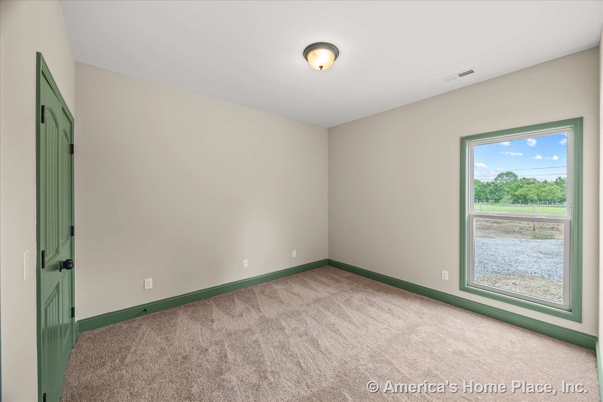 Green baseboards and window trim, green paneled door, beige carpet flooring, large single window with outdoor view, flush mount ceiling light, neutral wall color.