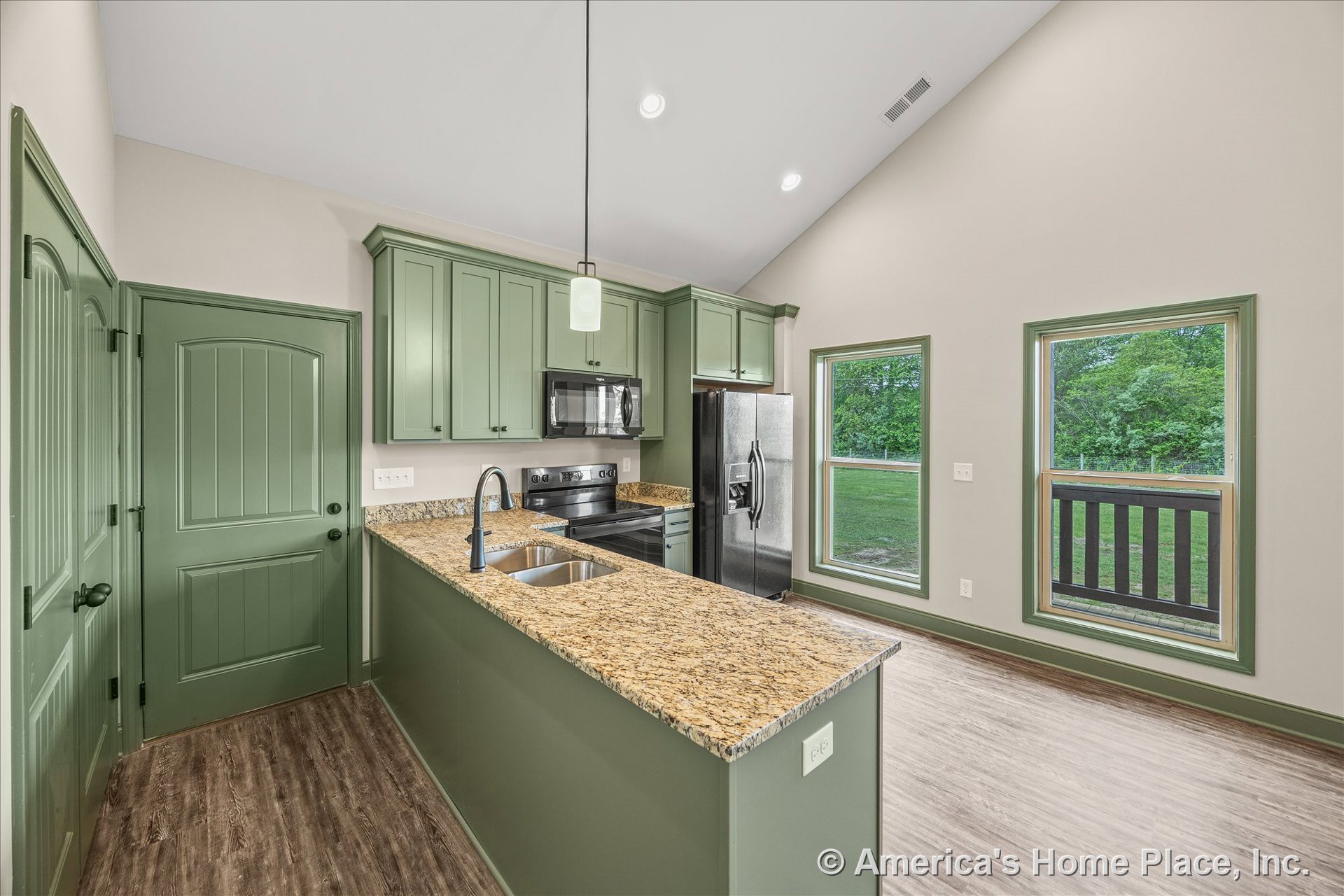Green shaker cabinets with granite countertops, stainless steel appliances, vaulted ceiling with recessed lighting, wood-look flooring, large windows featuring green trim, and