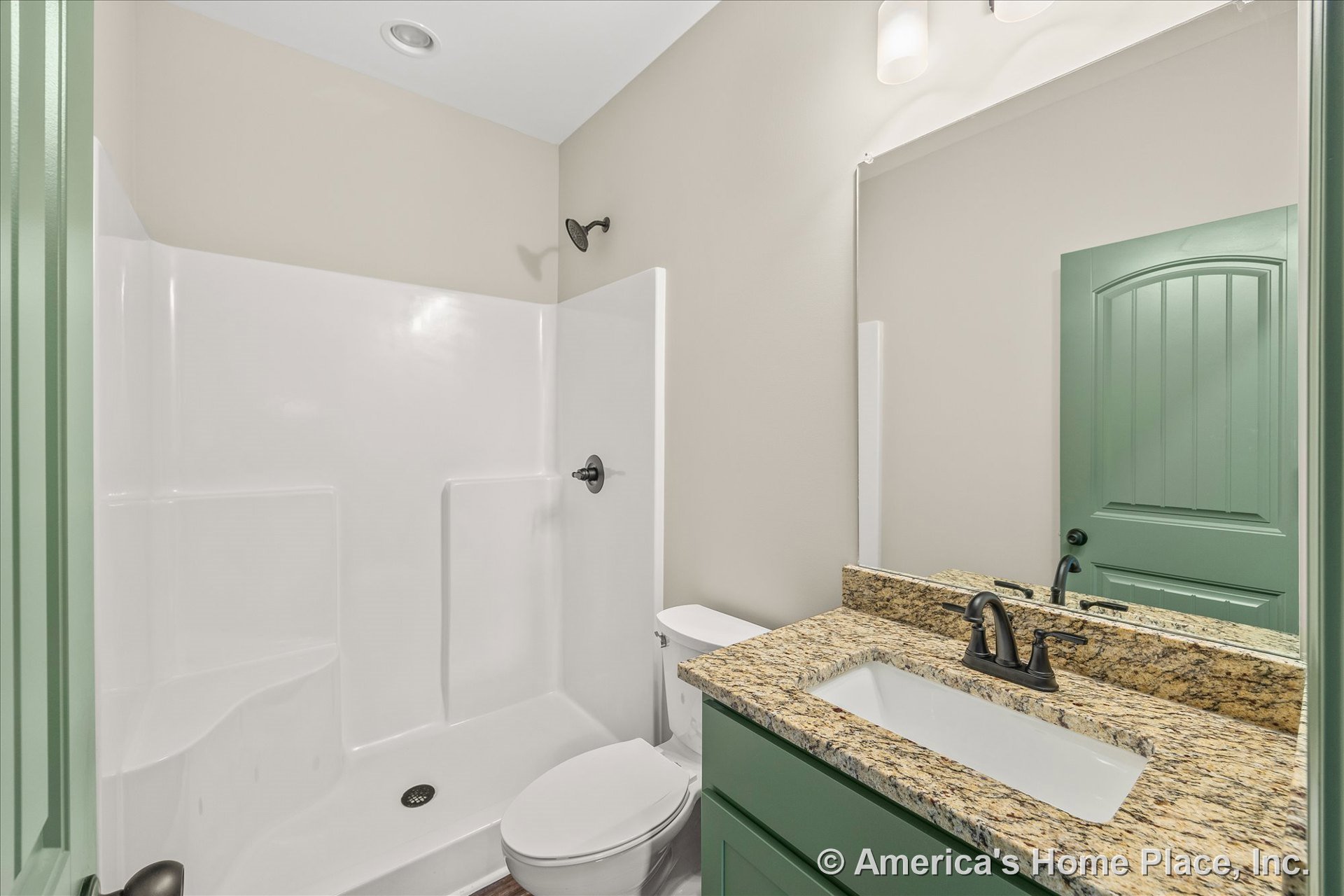 Walk-in shower with built-in seat and matte black fixtures, granite countertop vanity with green painted cabinetry, large wall mirror, recessed ceiling lighting, single sink