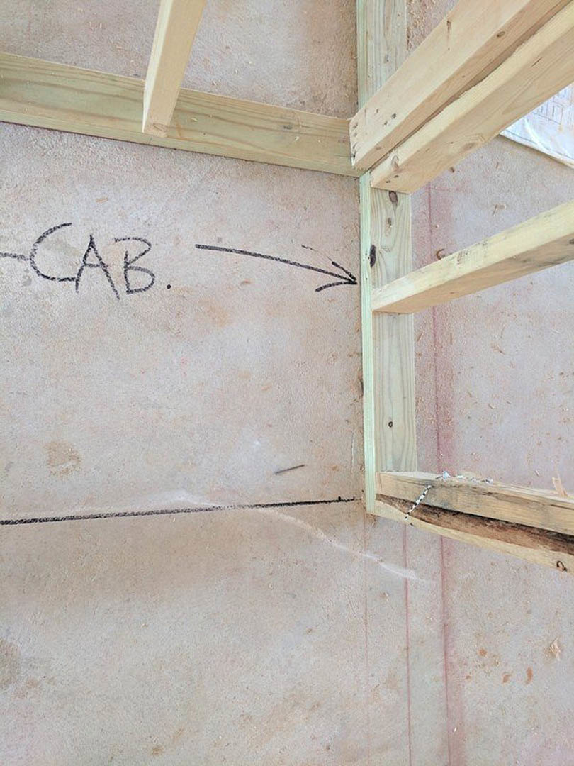 Wooden wall frame with handwritten text, light wood finish, close-up view in interior space