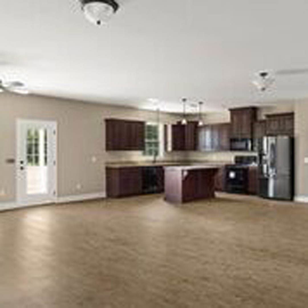 Spacious kitchen with laminate flooring, white cabinetry, central island, stainless steel refrigerator, and neutral walls