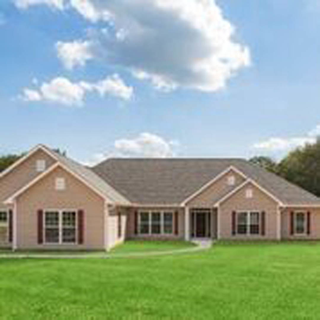 Two-story custom home with white siding, large windows, and gabled roof, surrounded by manicured green lawn under a partly cloudy blue sky