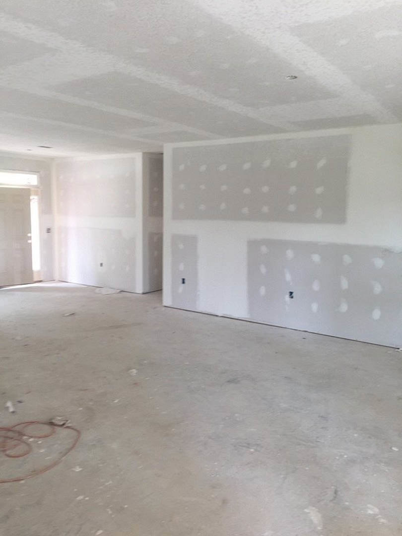 White-walled room with smooth plaster finishes, white ceiling, light streaming through a white door, and visible circular openings in the wall.