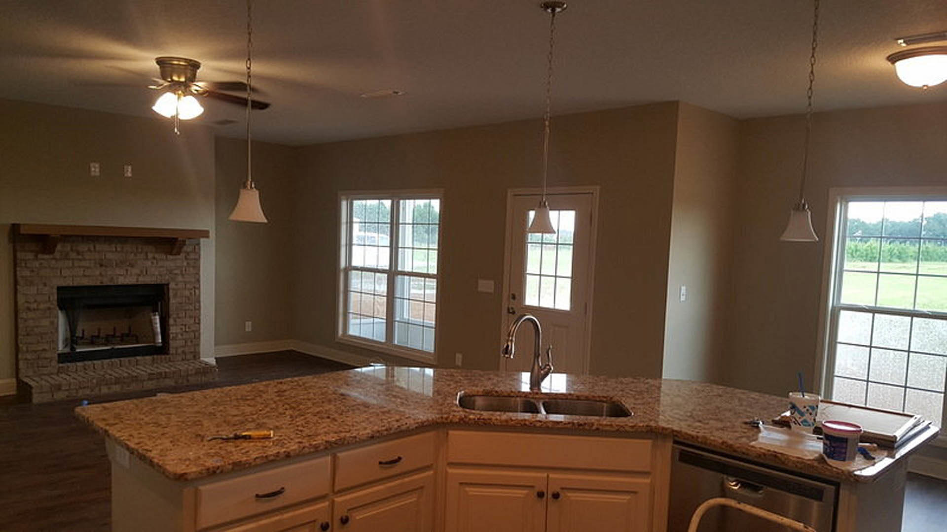Granite kitchen countertops with white cabinetry, stainless steel appliances, and tile backsplash