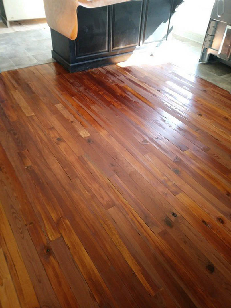 Kitchen featuring light wood flooring, black metal column, and partial view of a modern chair leg