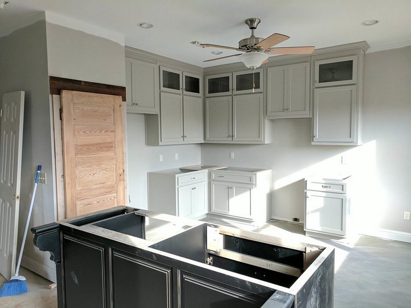 Kitchen with white cabinetry, ceiling fan with light fixture, stainless steel sink, and black and white countertop