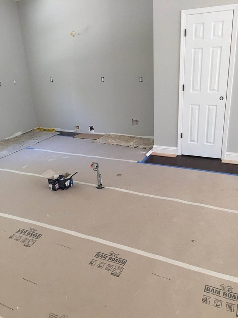 Room with white walls and white doors, white floor with subtle lines, metal pole featuring a red flag, close-up of a box displaying a tooth graphic.