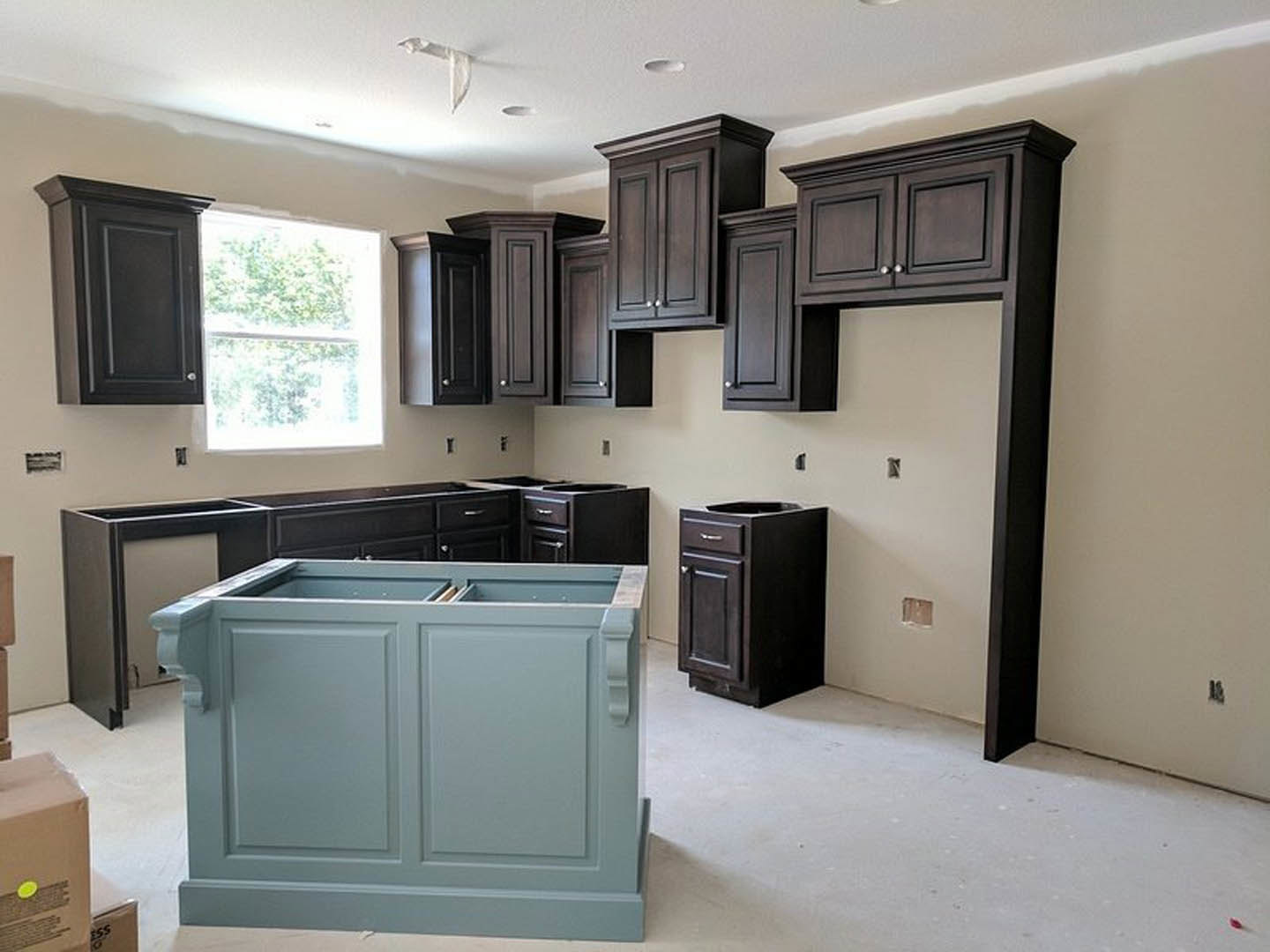 Kitchen with matte black cabinets, white quartz countertop, stainless steel sink, and a window with a white frame above the workspace