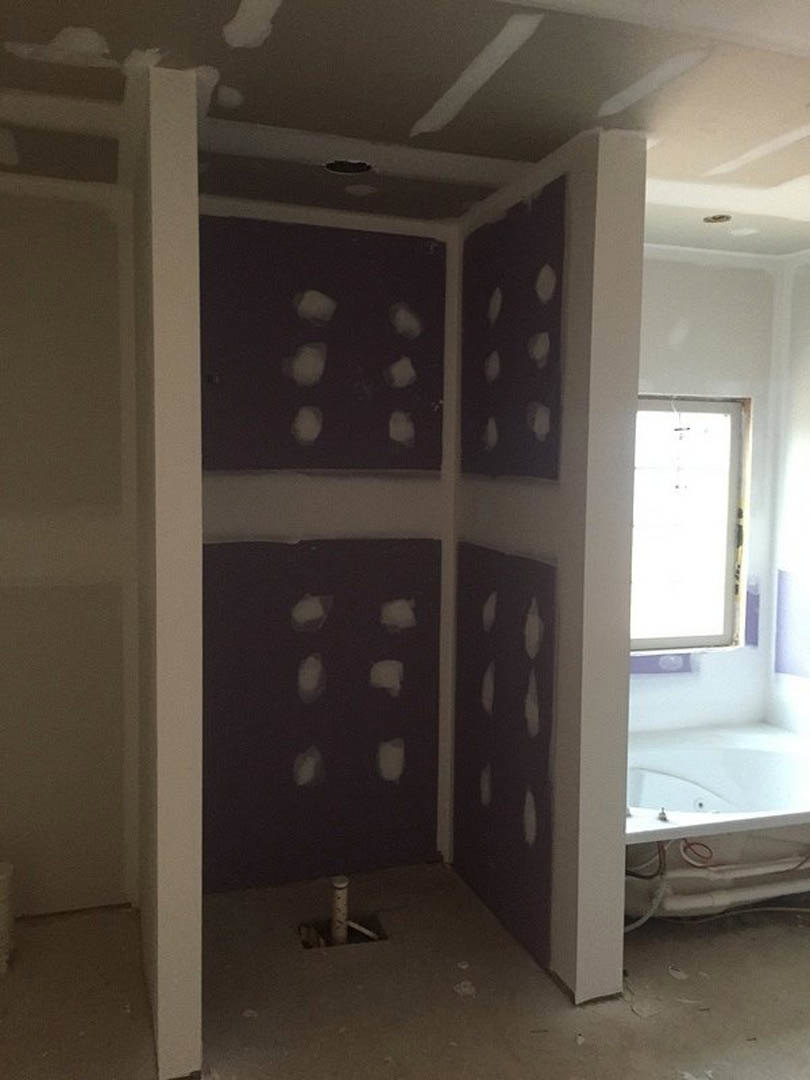 Shower room featuring smooth purple plaster walls, white rectangular shower enclosure with black handle, and light-colored flooring