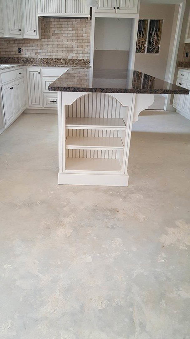 Kitchen island with black marble countertop, white cabinetry, open shelving, hardwood flooring, and white walls with framed artwork