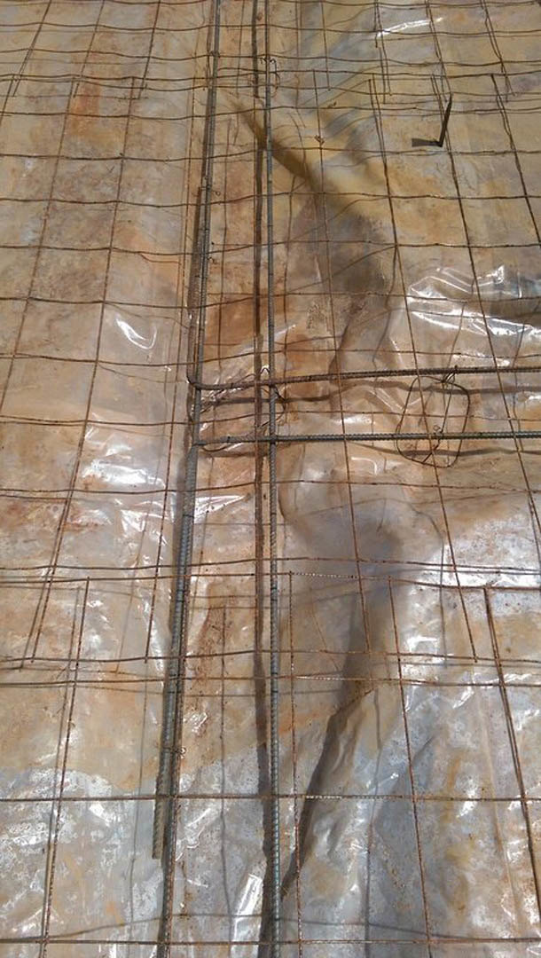 Close-up of a metal grid mesh laid over wooden floor planks