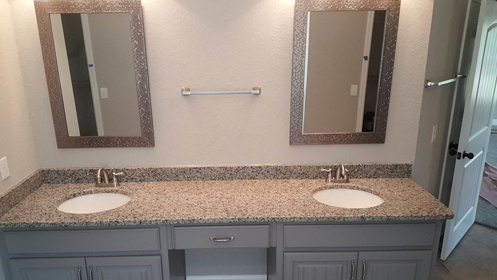 Bathroom with dual sinks, quartz countertop, large framed mirrors, chrome faucets, and white tile backsplash