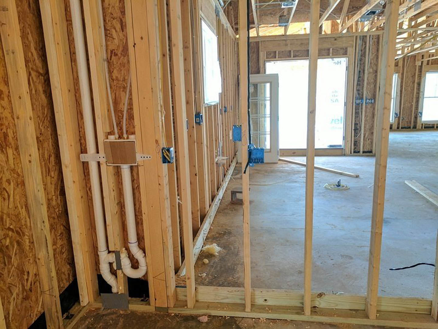 Bright room with light wood plank flooring, white walls, a single door, and a large window framed in white trim