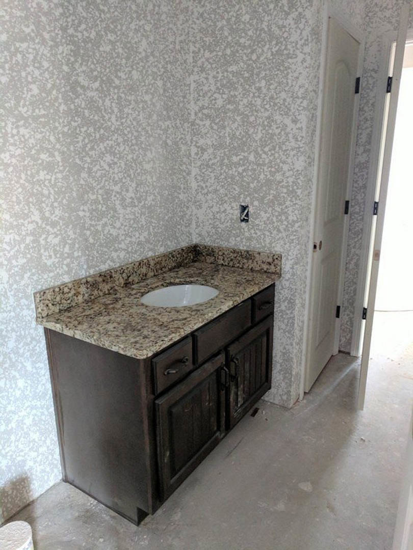 Marble countertop with undermount sink, chrome faucet, and tiled backsplash in a modern bathroom