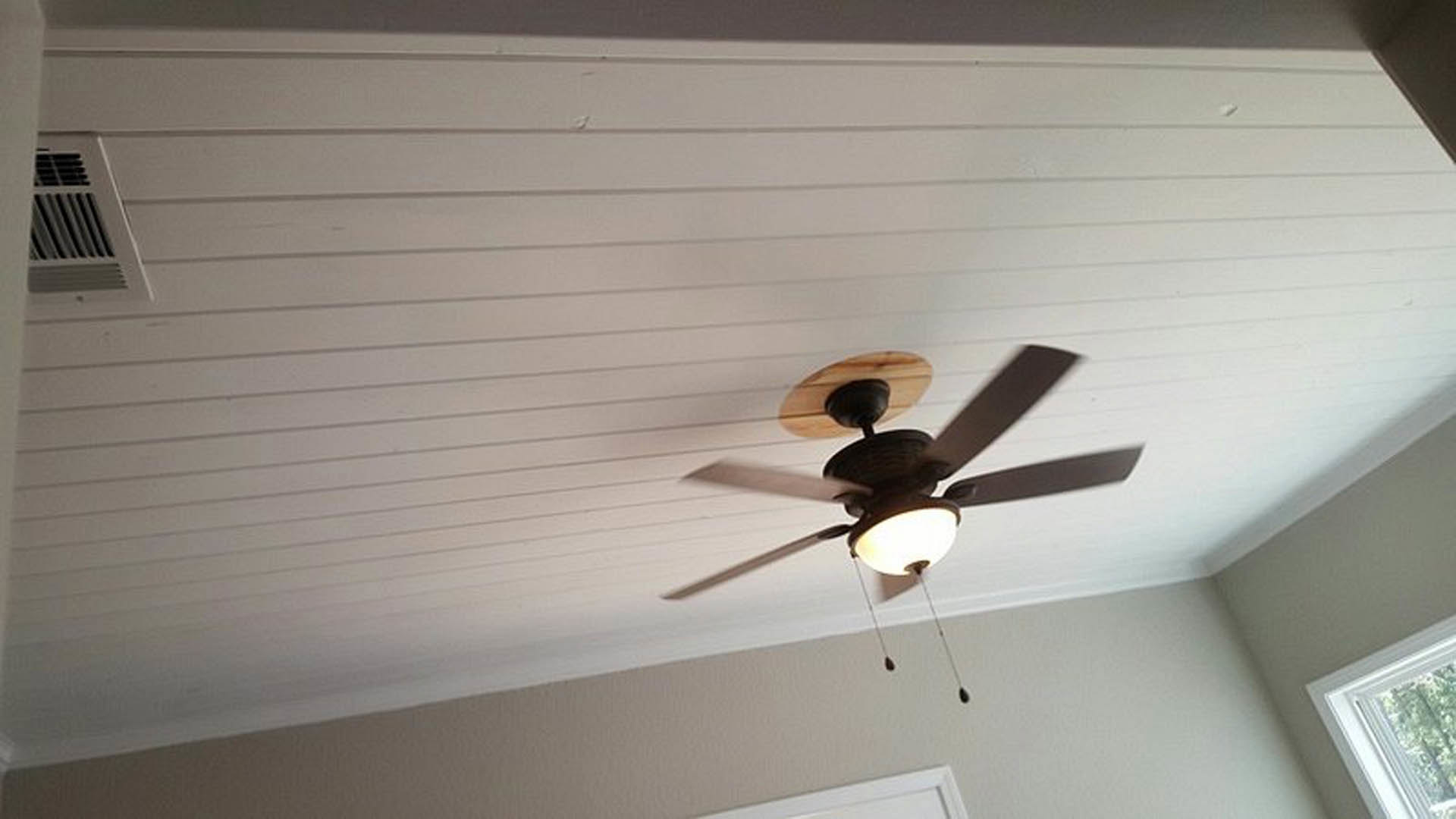 Ceiling fan with integrated light fixture mounted on white ceiling in residential interior