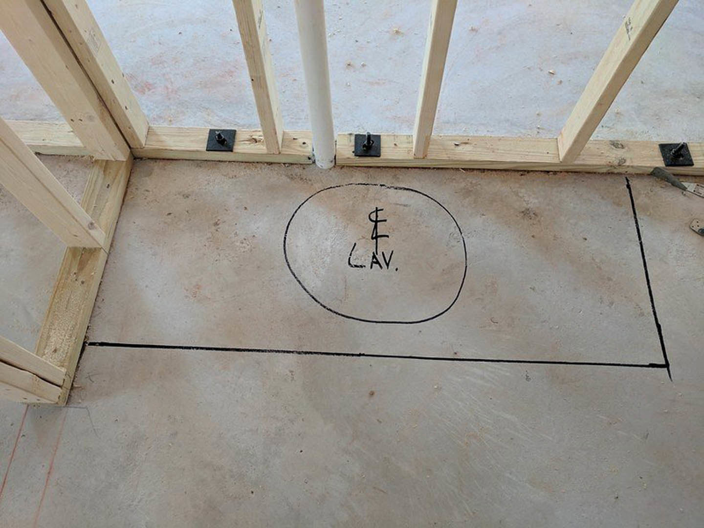 Concrete floor featuring a circular black line intersected by a white bar, surrounded by wood accents in an indoor residential space