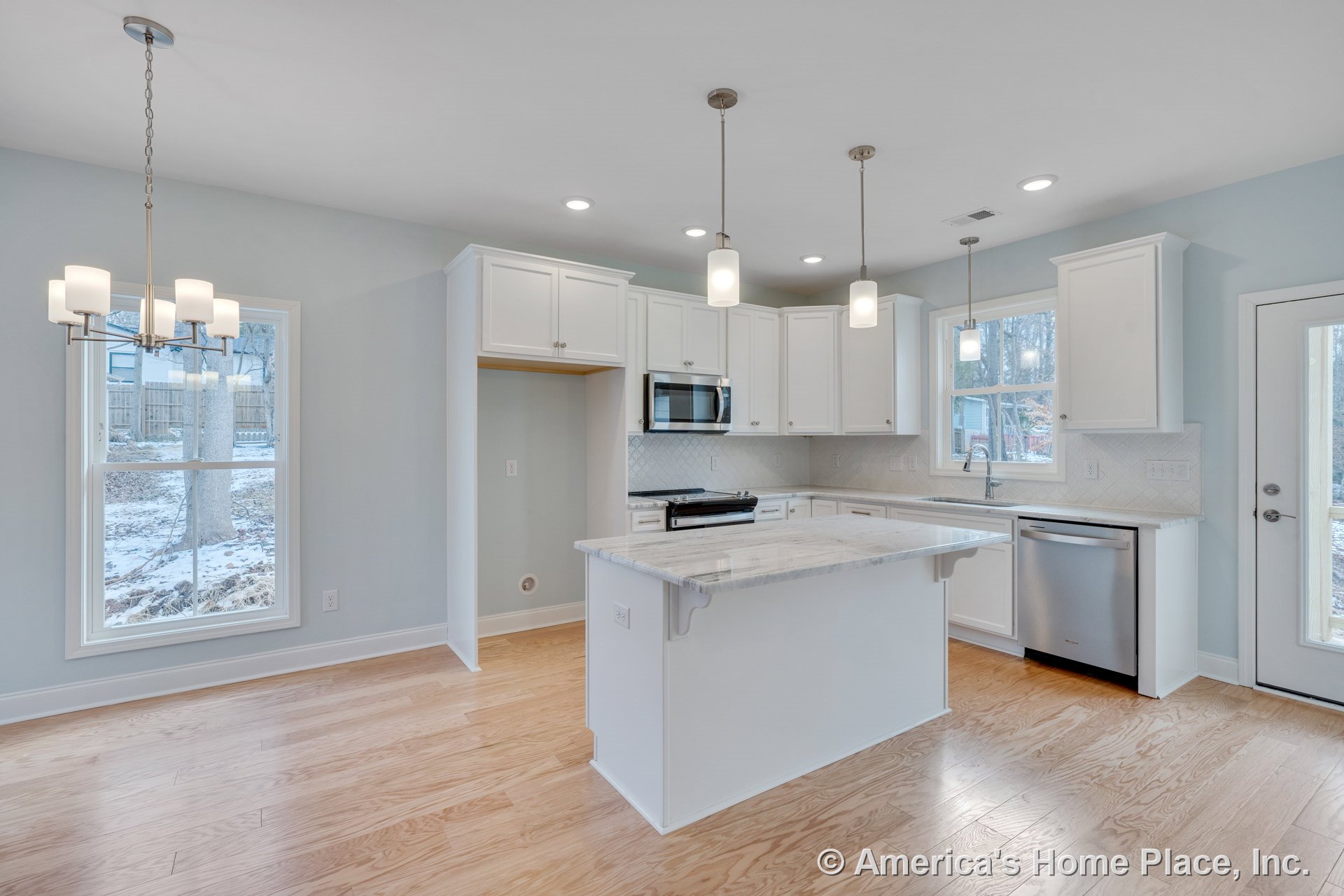 White shaker cabinets and marble kitchen island with pendant lighting, tile backsplash, stainless steel appliances, hardwood flooring, recessed lighting, and large windows in an