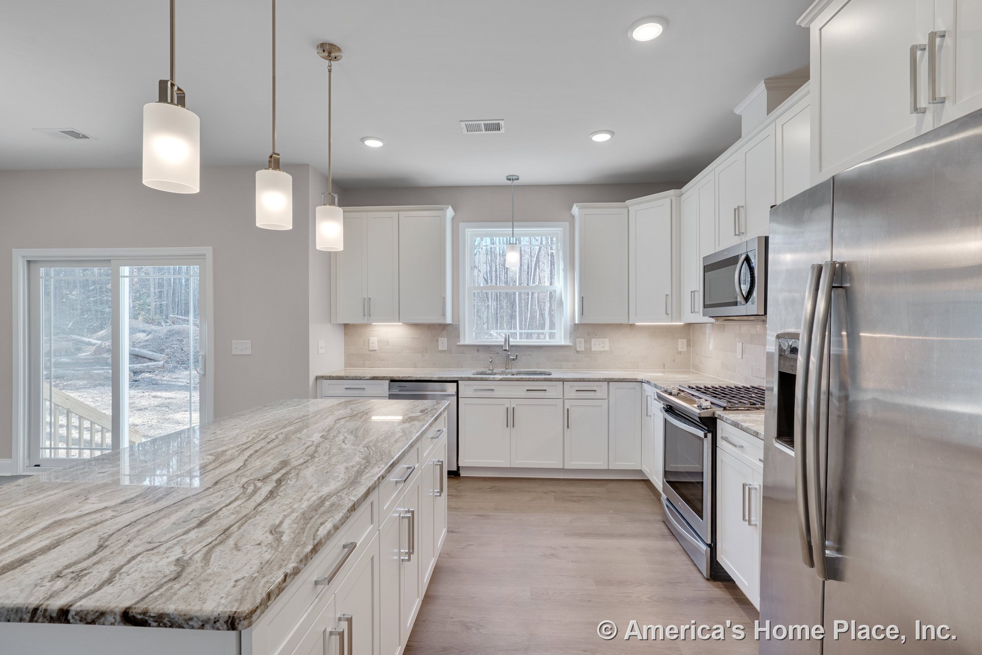 White kitchen with stone island countertop, stainless steel appliances, tile backsplash, wood flooring, white cabinetry, undermount sink, pendant and recessed ceiling lights