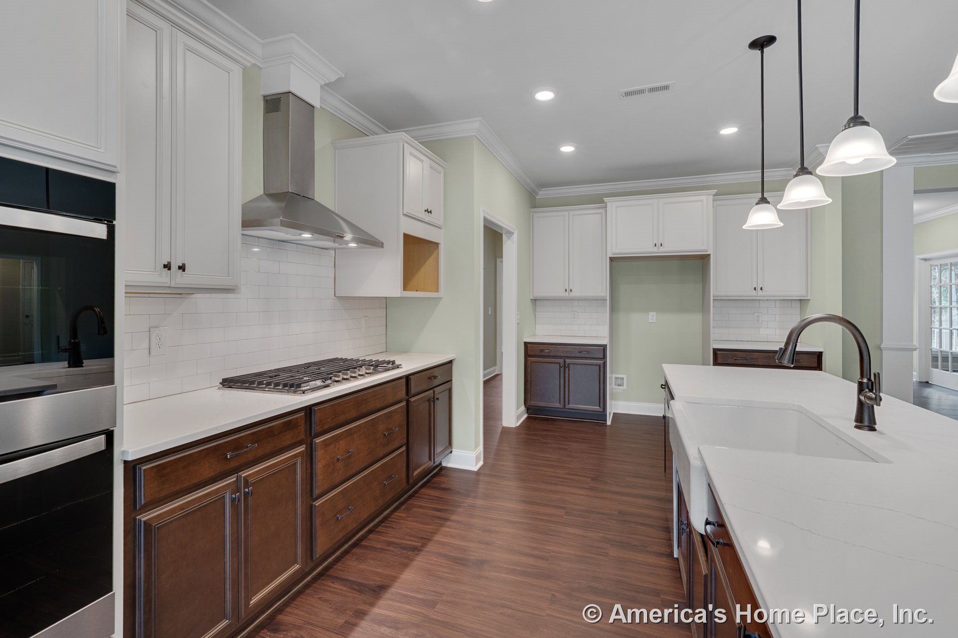 Custom kitchen with white upper cabinets, dark lower cabinets, quartz countertops, subway tile backsplash, double wall oven, stainless steel range hood, pendant lighting, farmhouse