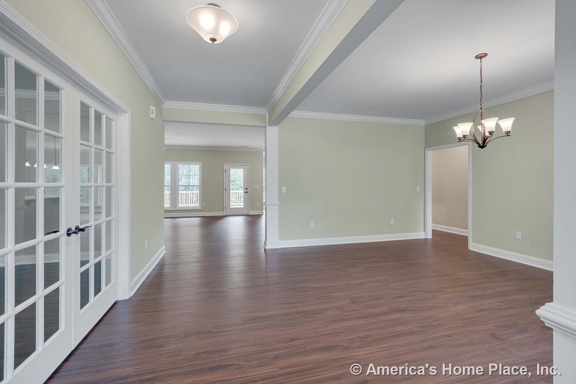 Open concept living and dining area with wood-look flooring, crown molding trim, French doors with glass panes, multiple ceiling light fixtures, large windows, and a dining space