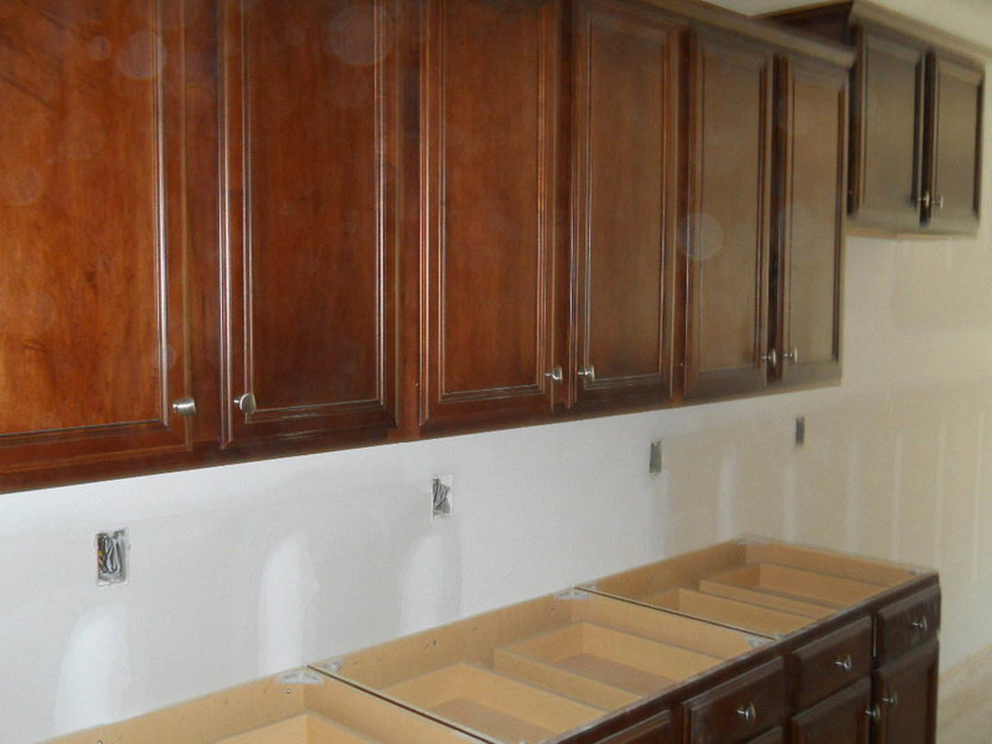Kitchen with light wood cabinets, white countertop, stainless steel sink, and modern drawer pulls