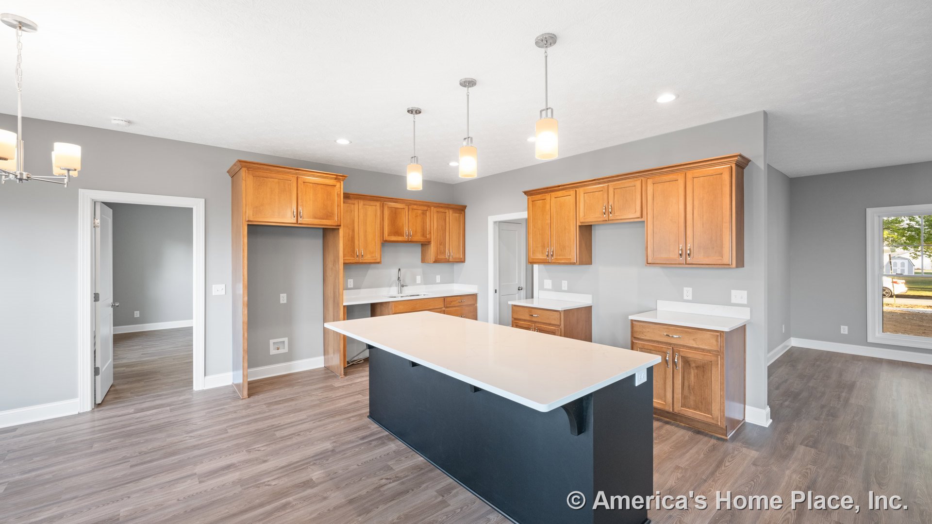 Wood upper and lower cabinets with white quartz countertops, large central kitchen island beneath pendant lights, gray painted walls, wide plank vinyl flooring, recessed lighting