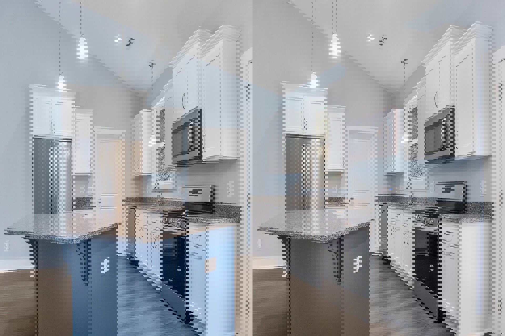 White cabinetry and blue walls in a kitchen with stainless steel refrigerator, microwave oven, stove, and kitchen island.