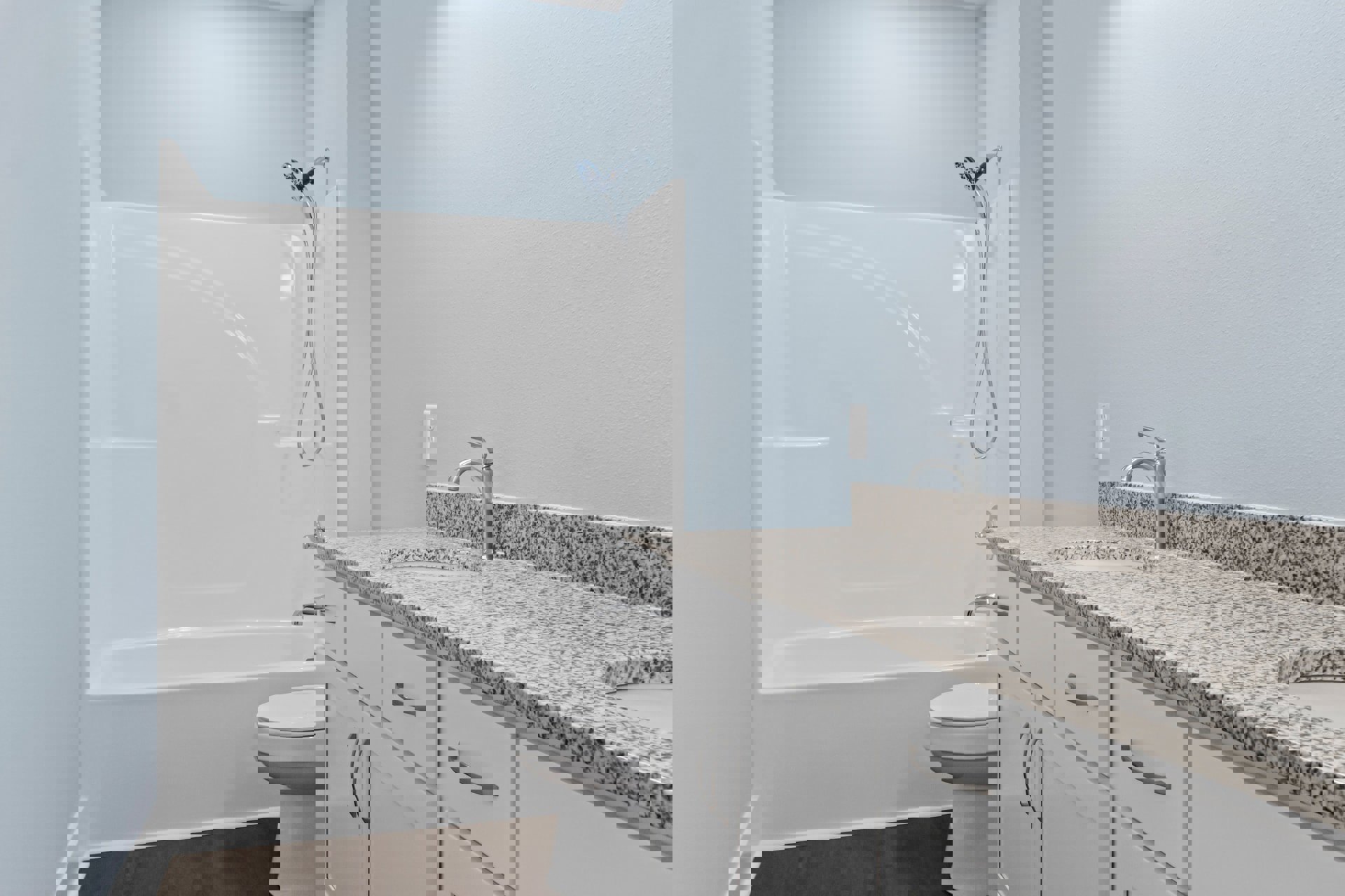 Modern bathroom featuring a white tile shower with glass door, white toilet, light-colored countertop with white drawers, and silver faucet.