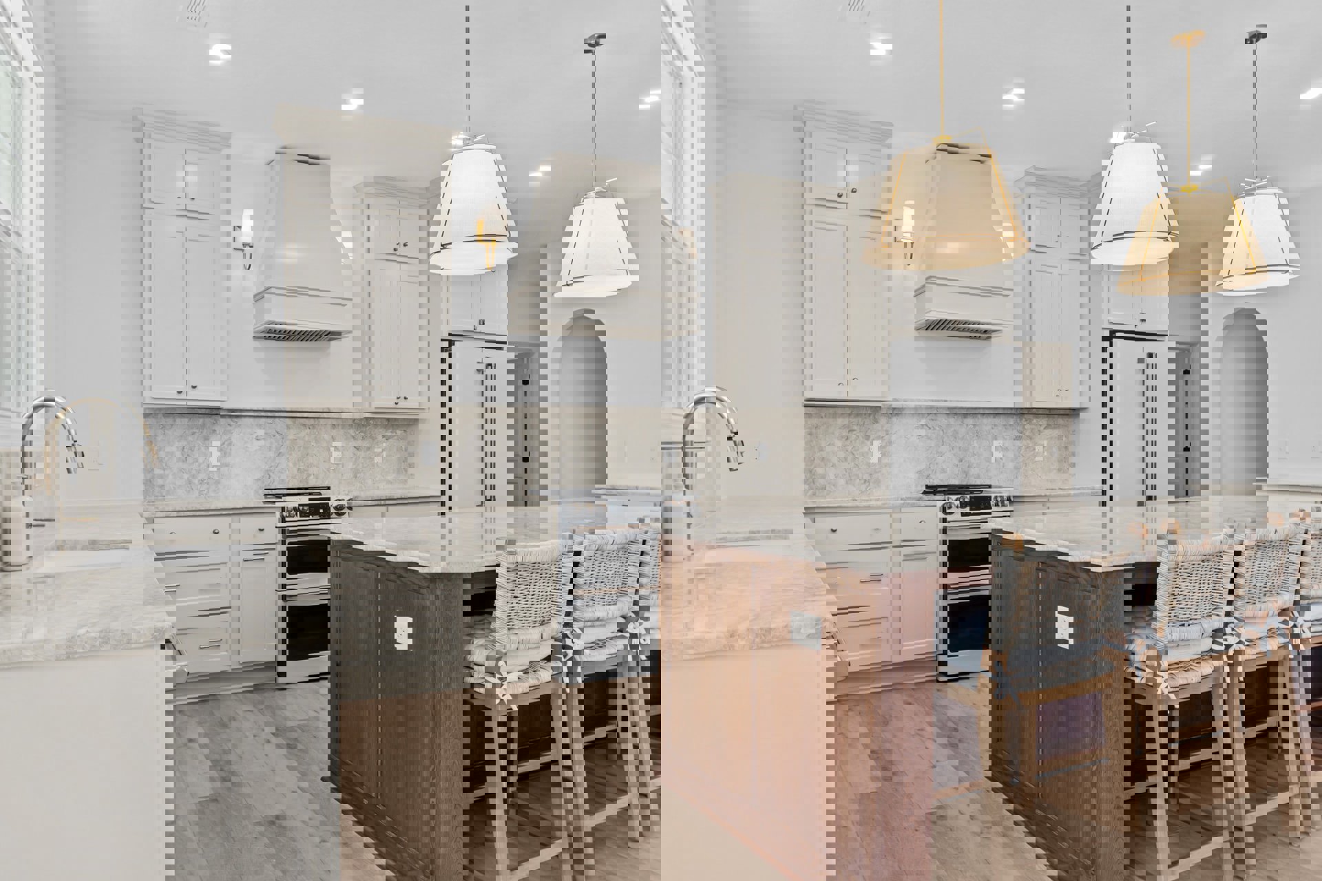 Modern kitchen featuring a central island with cushioned chairs, white stove with black oven windows, white vent hood with built-in lights, white cabinetry, light fixture with