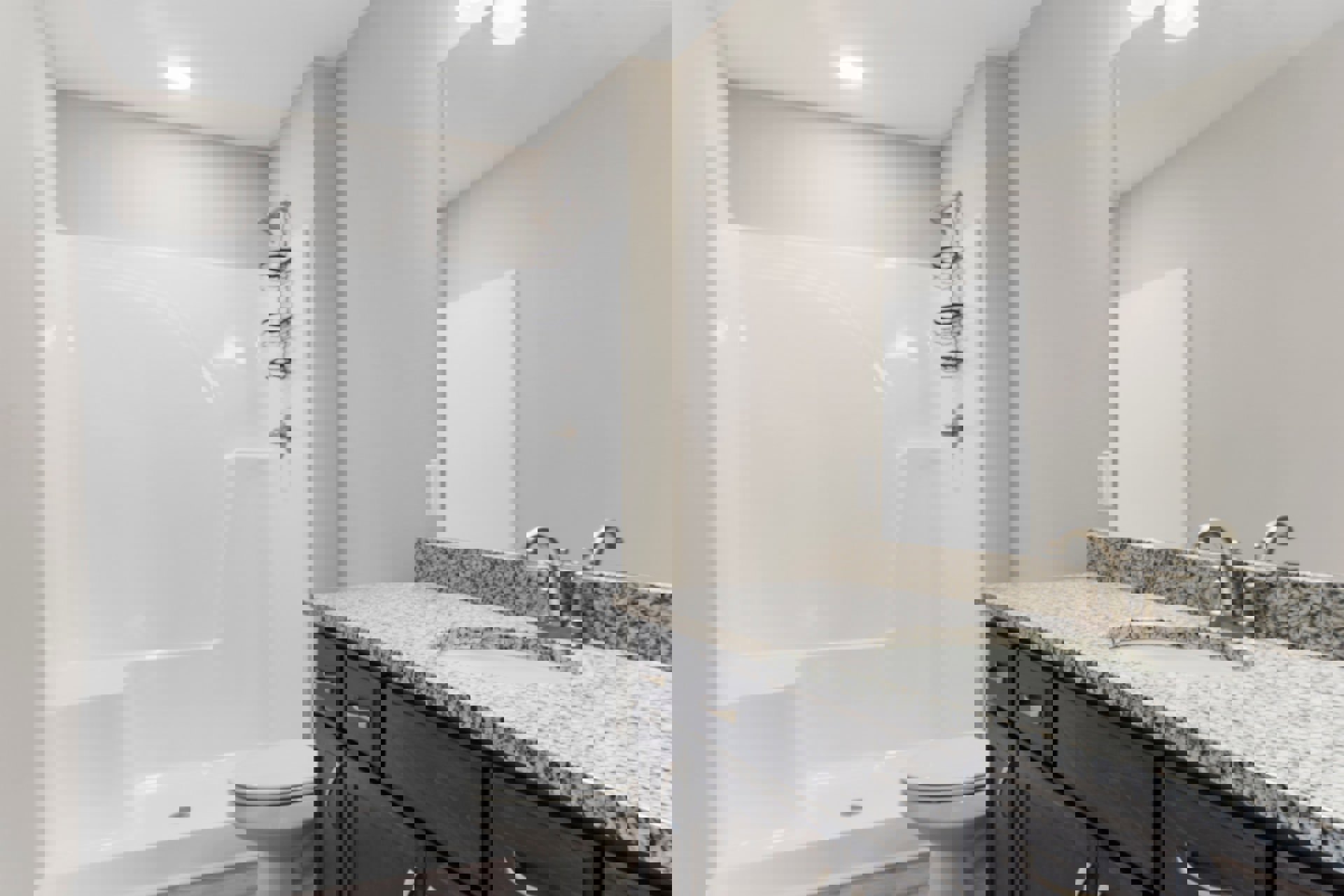 Modern bathroom featuring a white tile shower with glass door, wall-mounted sink with chrome faucet, white toilet, and light wood cabinetry.