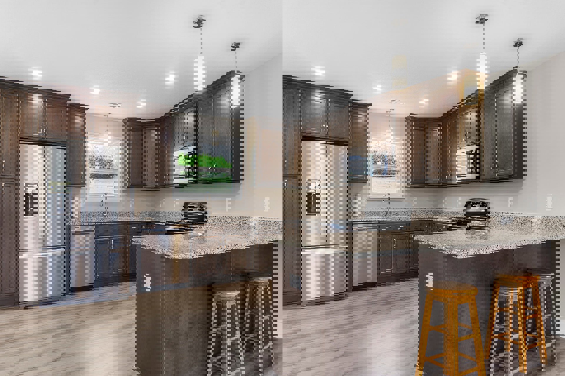 Granite kitchen countertop with a wooden stool, stainless steel refrigerator, white cabinetry, stove, and window overlooking a grassy field