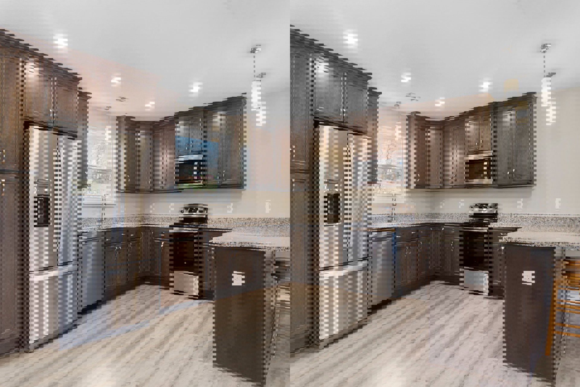 Stainless steel refrigerator, stove, and microwave set against white cabinetry and countertops, with a wooden chair leg visible near a white wall.