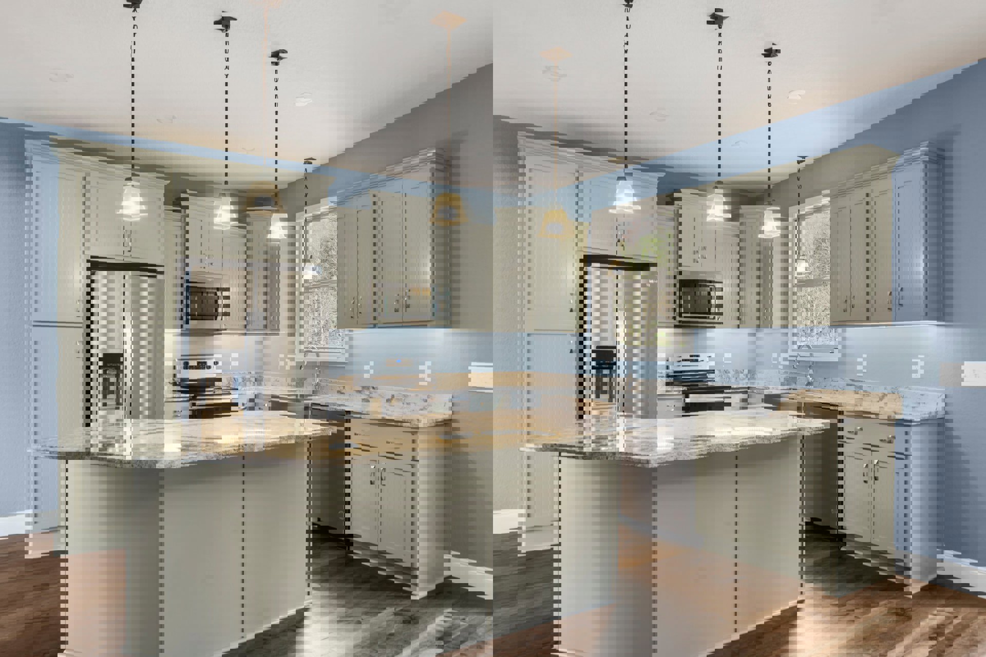 Marble island with waterfall edge, stainless steel refrigerator and stove, white cabinetry, undermount sink, light wood flooring