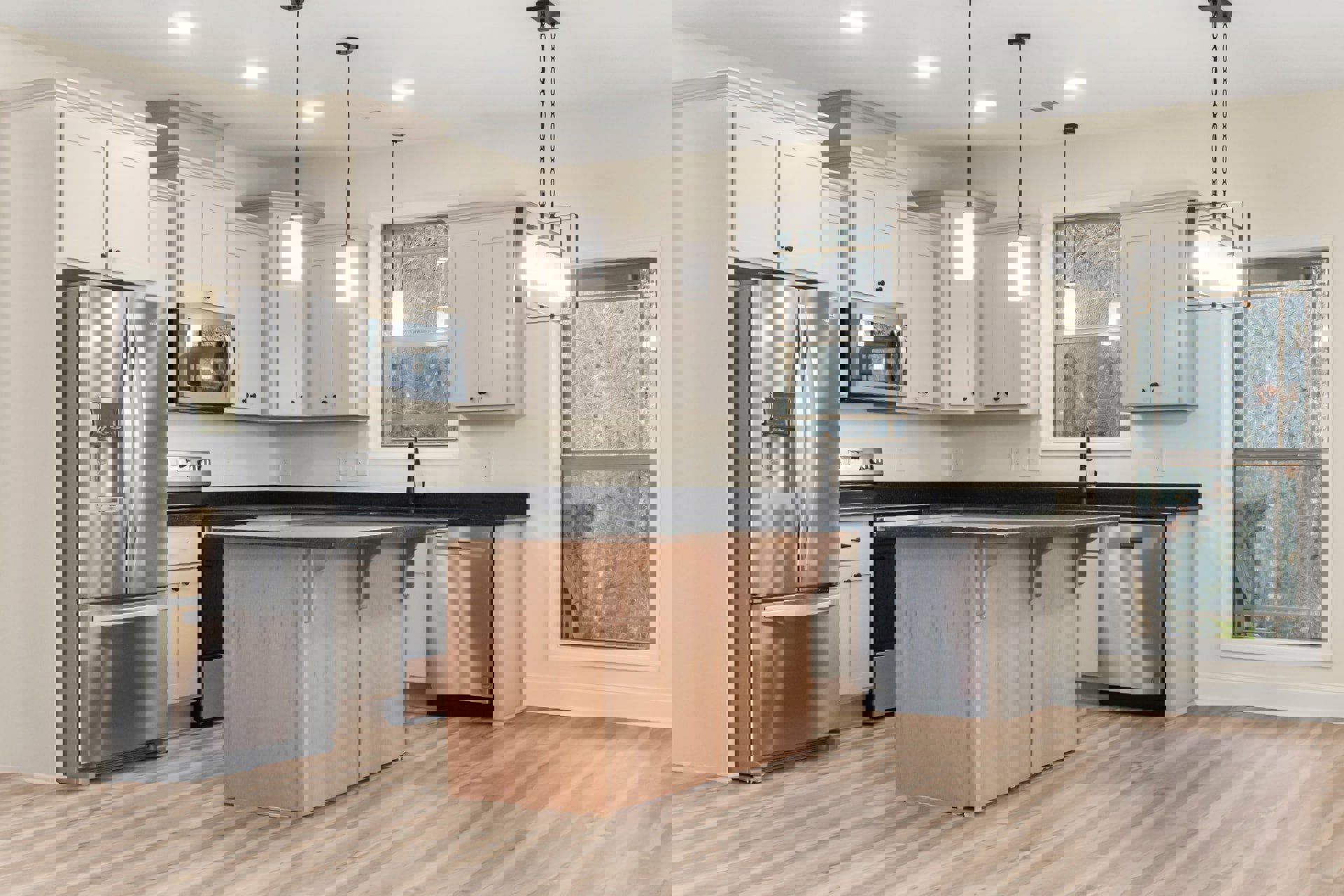 Kitchen with wooden island featuring black countertop, stainless steel refrigerator with black handle, built-in microwave with glass door, frosted glass window, light cabinetry