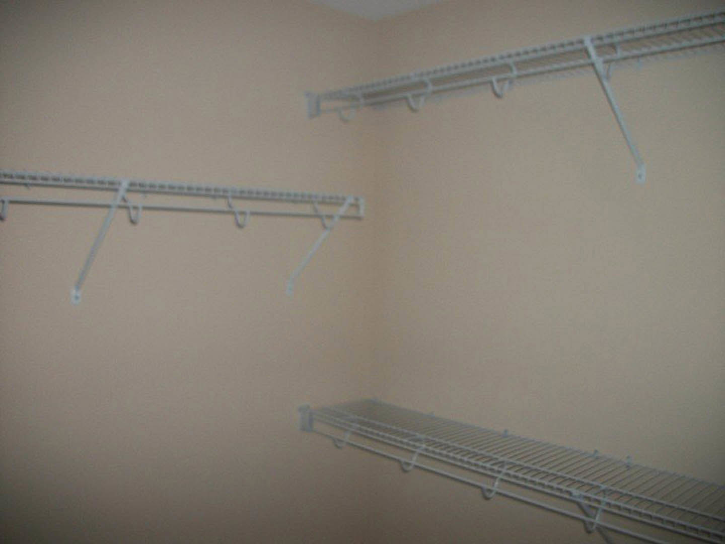 White built-in shelves mounted on a plaster wall in a room, with clean lines and minimalist design.