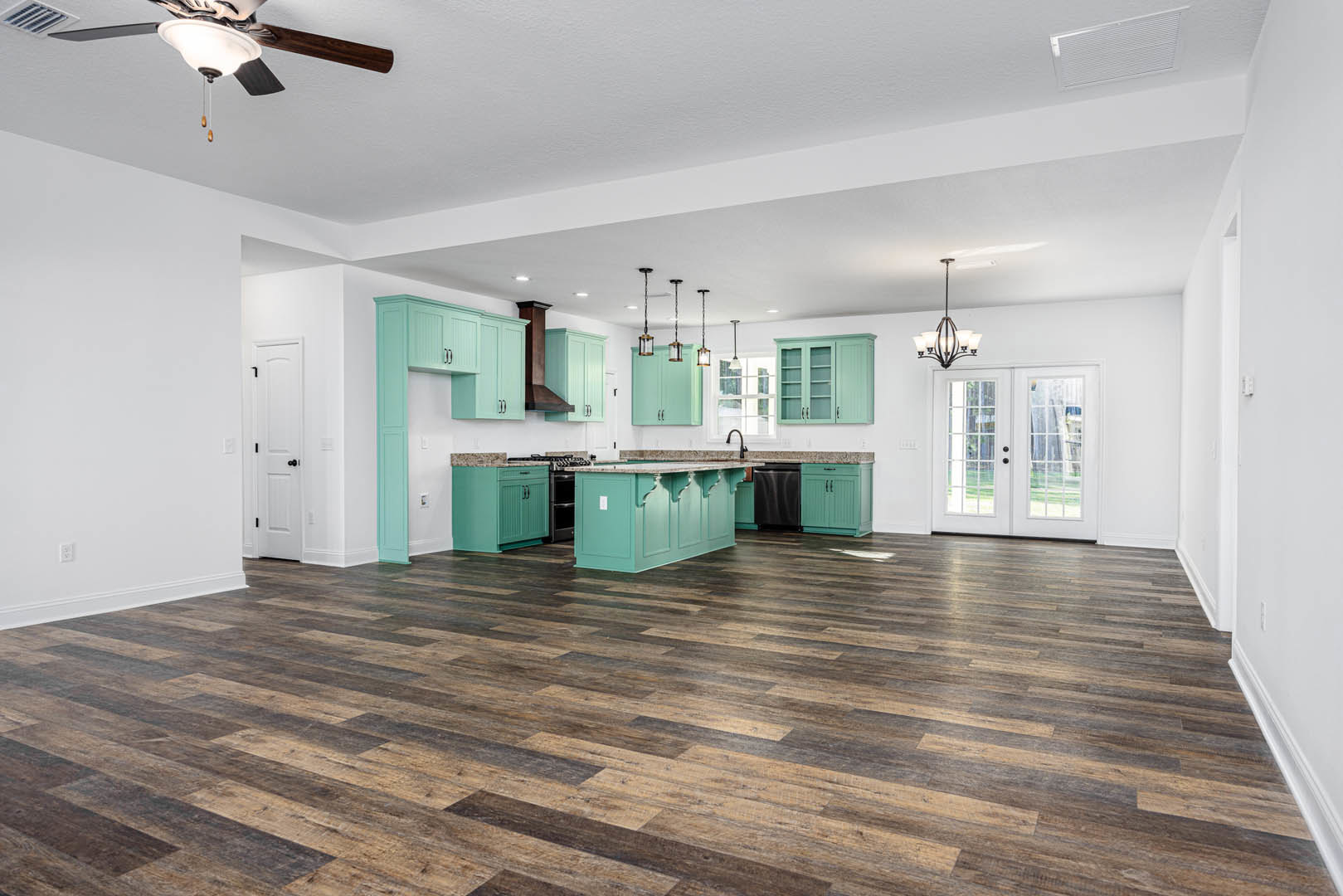 Open kitchen with blue walls, wood flooring, glass-paneled double doors, white cabinetry, black dishwasher, ceiling fan, and white door with black knobs