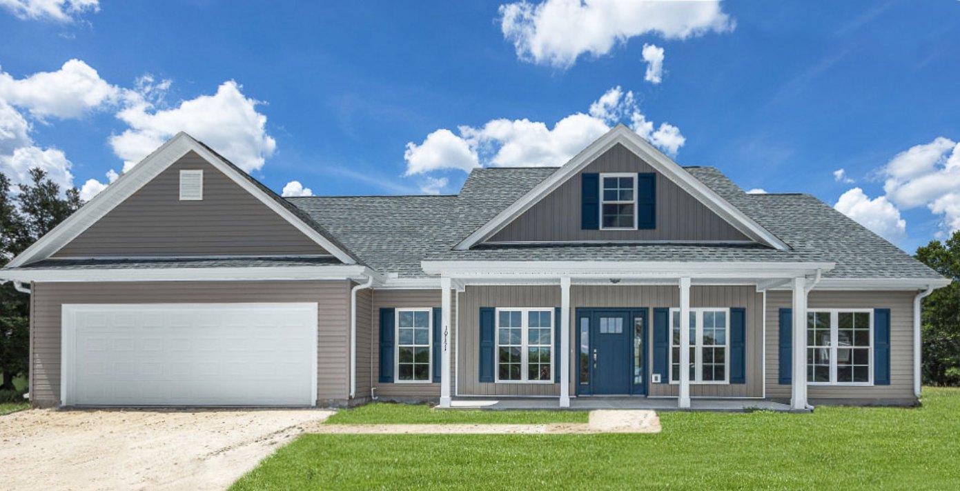 White stucco house with brown trim, blue front door with glass panels, blue shuttered windows, green lawn under clear blue sky, baseball bat lying in grass