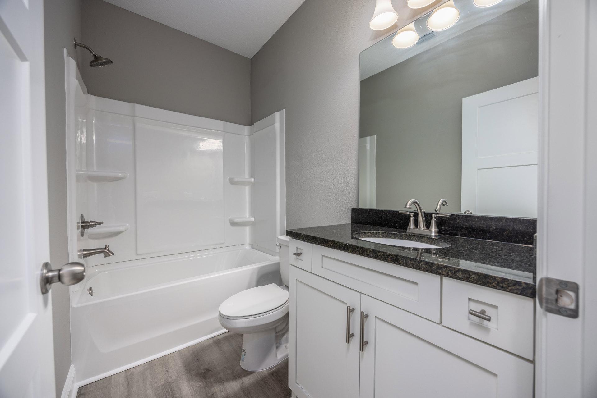 White bathroom featuring a freestanding bathtub, pedestal sink, closed-lid toilet, tiled walls, and a shower with a white curtain