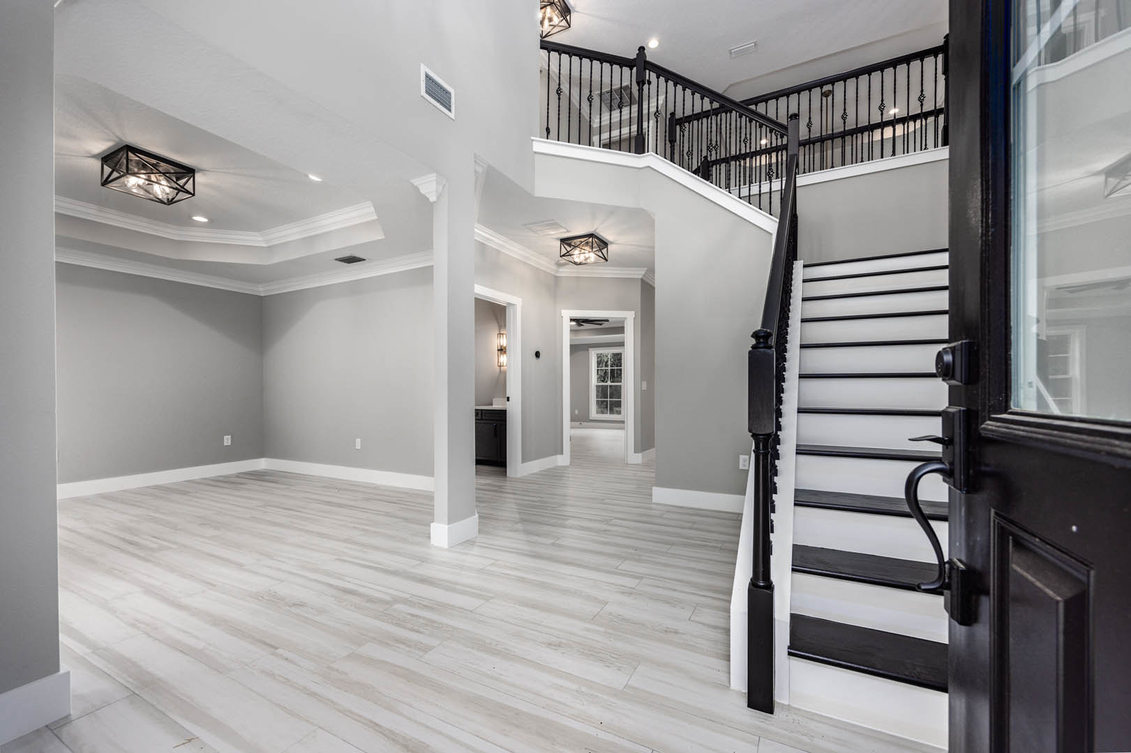 Wood staircase with white risers and handrail, star-shaped ceiling light fixture, glass shade pendant, wall vent, crown molding, plaster walls, hardwood flooring, and doorway in