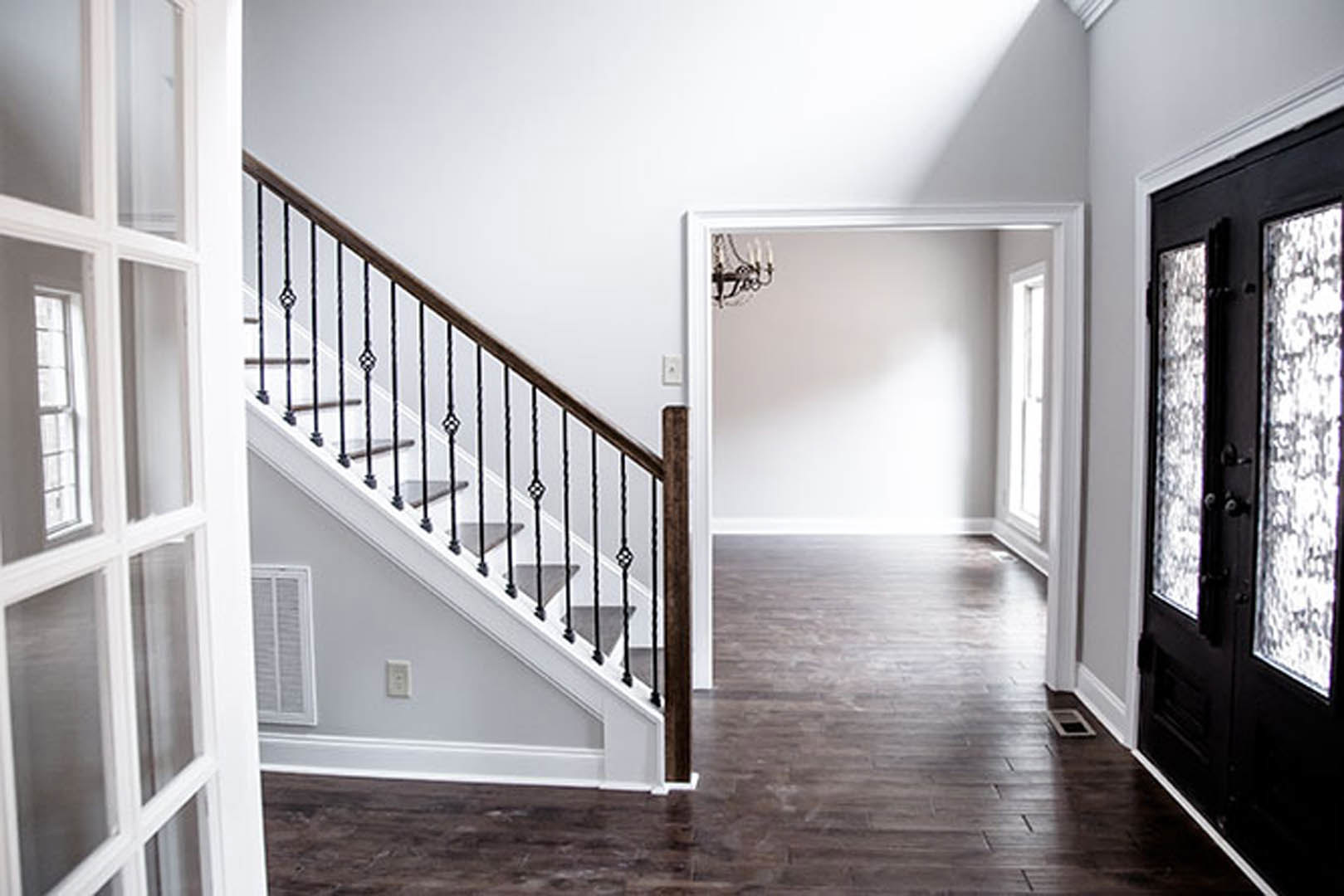 Wood staircase with metal railings, light-colored walls, and hardwood flooring in a modern residential interior