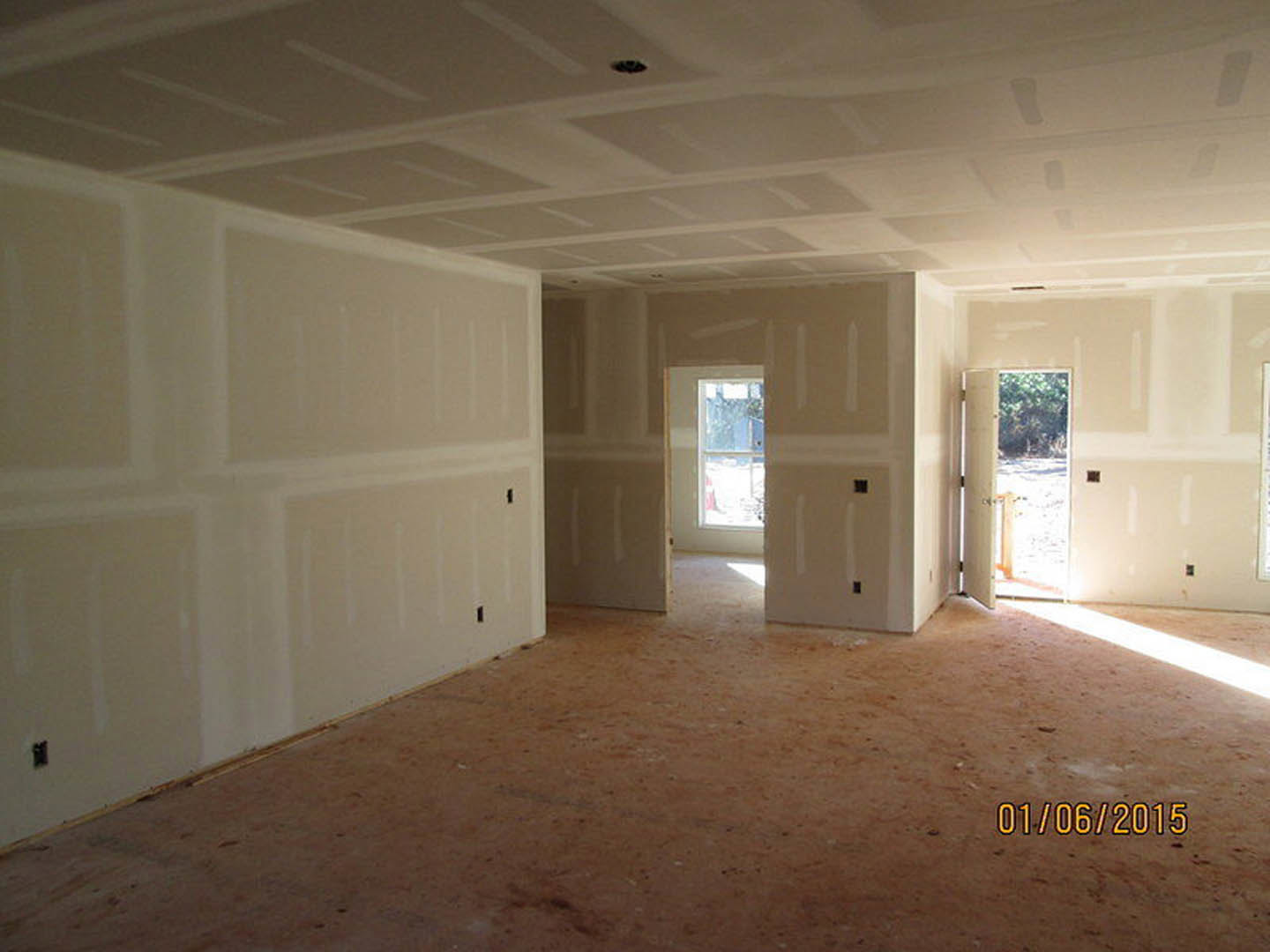 White-walled room with a white-framed door opening to a snowy landscape, vented ceiling, and light-colored flooring