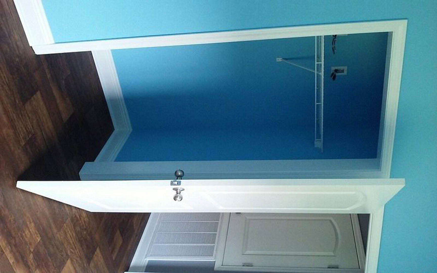 Blue accent wall with white door and white trim, cabinetry visible in foreground, indoor residential space.