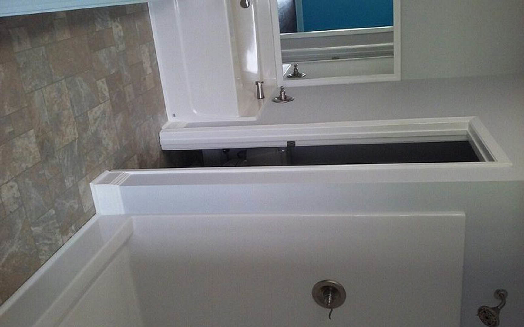 Modern bathroom with freestanding marble bathtub, large wall mirror, plaster walls, chrome faucet, and marble countertop sink