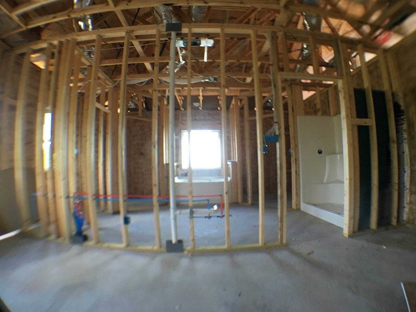 Bathroom with freestanding tub, wood-framed window, exposed ceiling beams, light-colored walls, and tiled floor