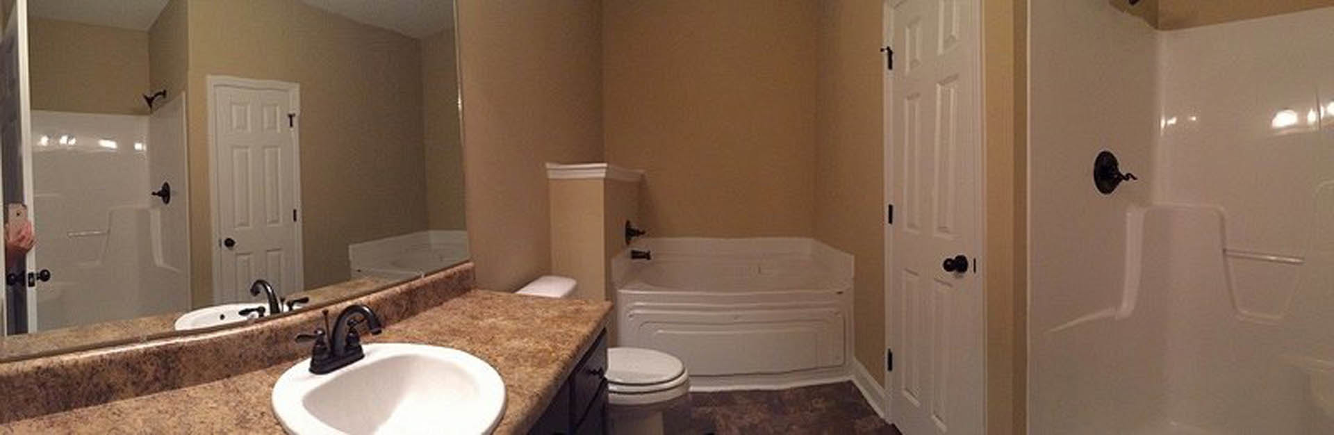 Modern bathroom with white porcelain sink and toilet, light tile flooring, neutral wall color, chrome faucet, and partial view of a door.
