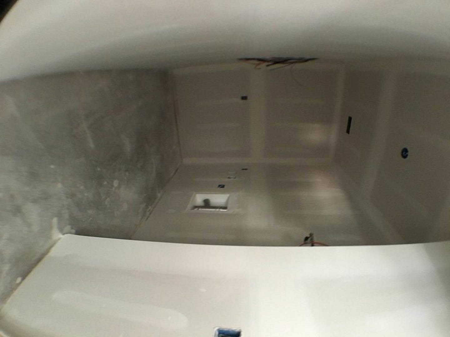 White-walled bathroom with a white door, white toilet, and smooth white flooring