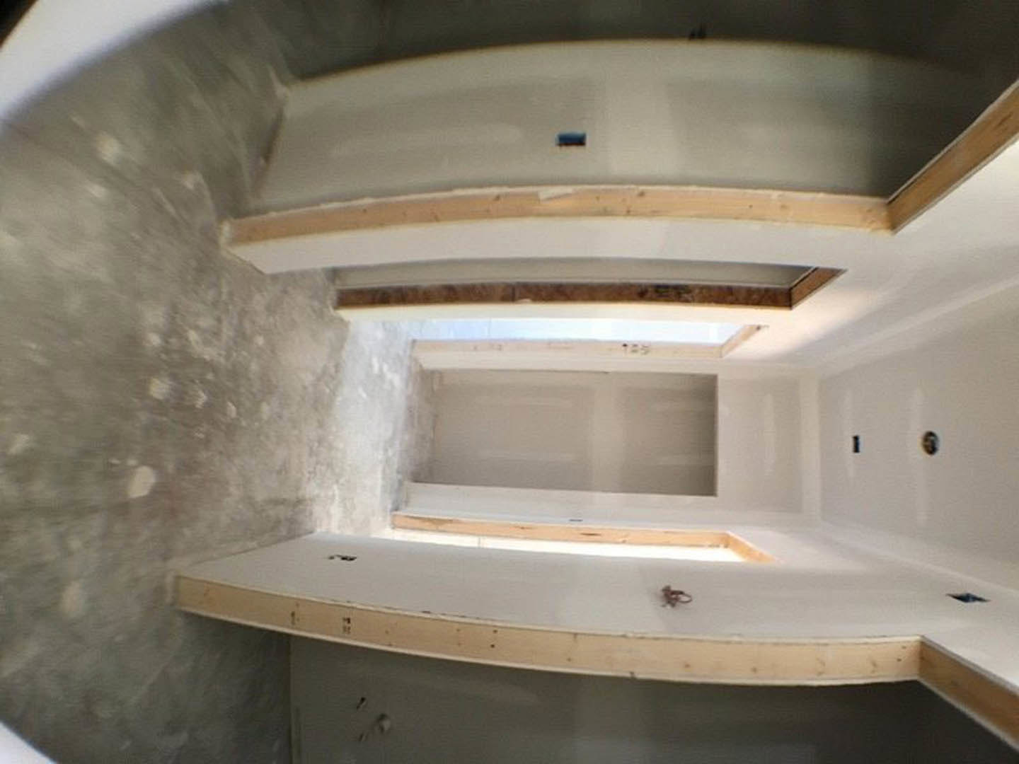 White-walled room with a single door, minimal fixtures, and smooth ceiling